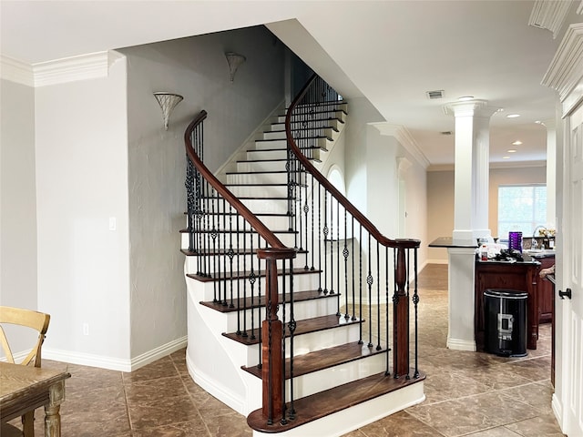 stairway with sink, decorative columns, crown molding, and tile patterned floors