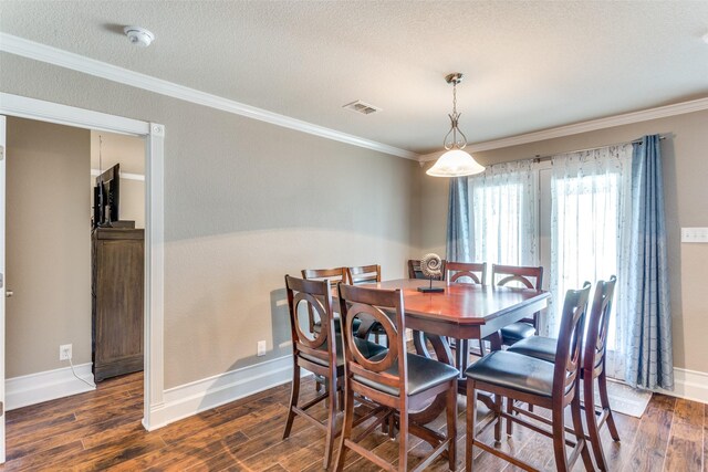 dining space featuring ornamental molding, dark wood-type flooring, and a textured ceiling