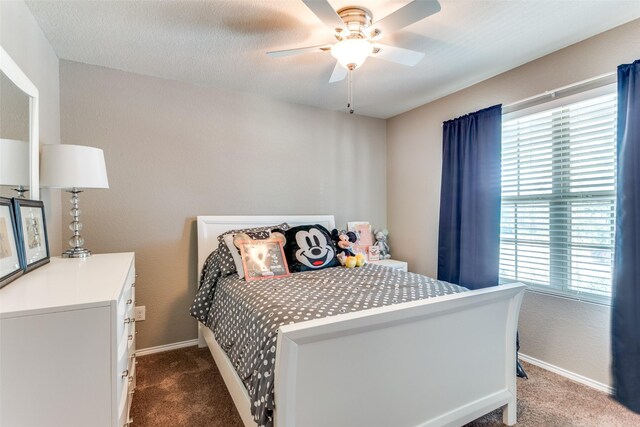 carpeted bedroom featuring a textured ceiling, multiple windows, and ceiling fan