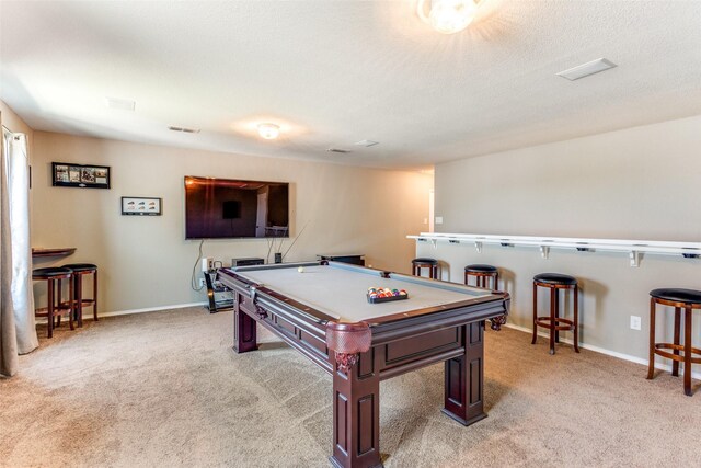 playroom featuring pool table, a textured ceiling, and light carpet