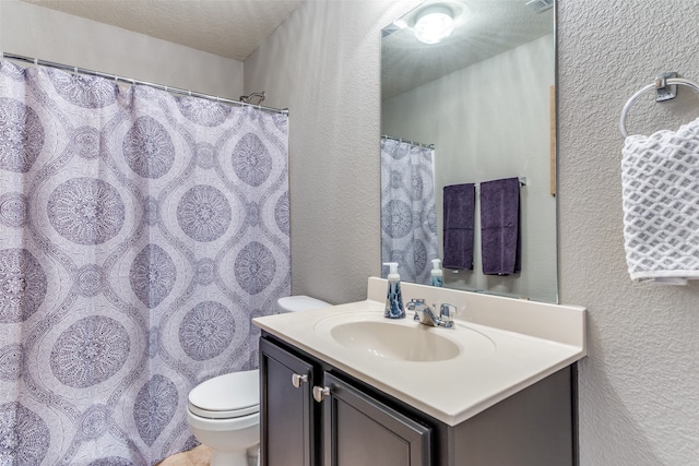 bathroom with vanity, a textured ceiling, and toilet