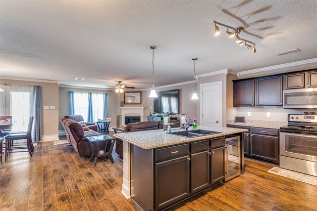 kitchen featuring a kitchen island with sink, appliances with stainless steel finishes, sink, and dark hardwood / wood-style floors