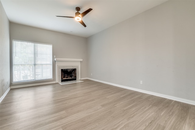 unfurnished living room with light hardwood / wood-style floors, a fireplace, and ceiling fan