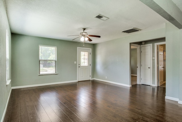 unfurnished room with dark wood-type flooring, a textured ceiling, and ceiling fan