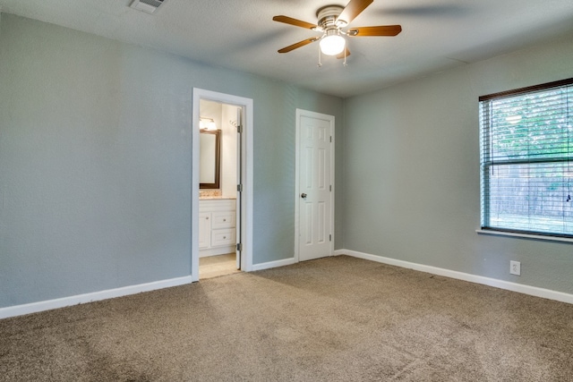 unfurnished bedroom with carpet flooring, ensuite bathroom, and ceiling fan