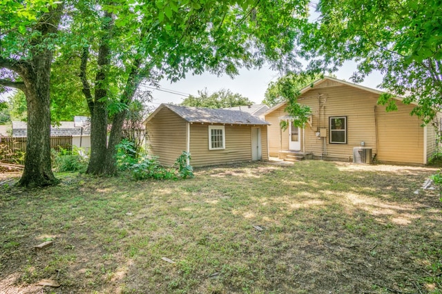 rear view of house featuring a yard and central AC