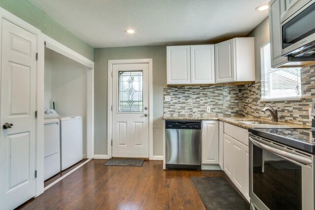 kitchen featuring tasteful backsplash, white cabinets, appliances with stainless steel finishes, independent washer and dryer, and dark wood-type flooring