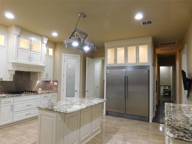 kitchen featuring white cabinetry, decorative backsplash, appliances with stainless steel finishes, and visible vents
