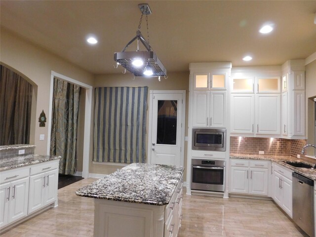 kitchen featuring appliances with stainless steel finishes, white cabinets, and decorative backsplash