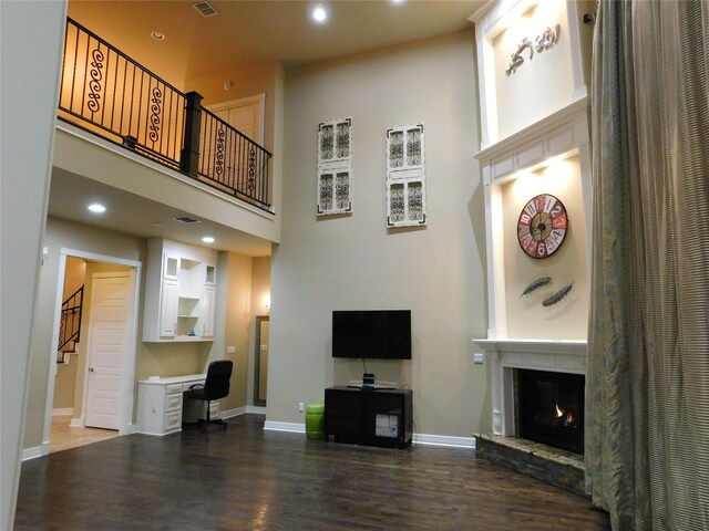 living room with hardwood / wood-style flooring and a towering ceiling