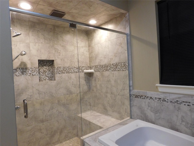 bathroom with a bath, visible vents, and a stall shower