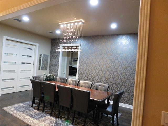 dining area with a notable chandelier and dark hardwood / wood-style floors