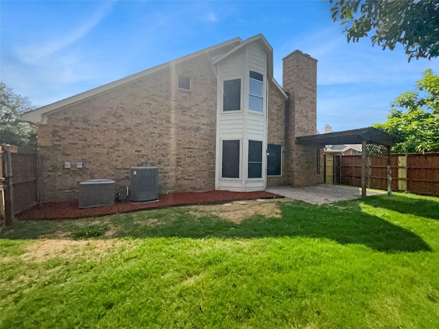 back of house featuring a lawn, a patio area, and central air condition unit