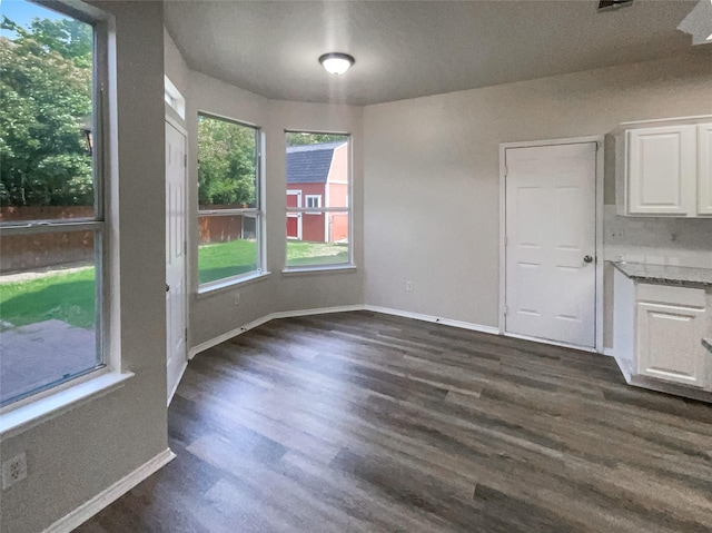 unfurnished dining area featuring dark hardwood / wood-style flooring