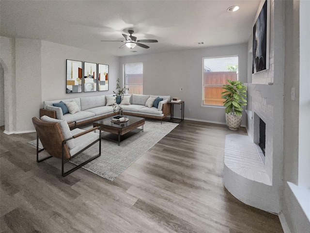 living room with a fireplace, hardwood / wood-style flooring, and ceiling fan