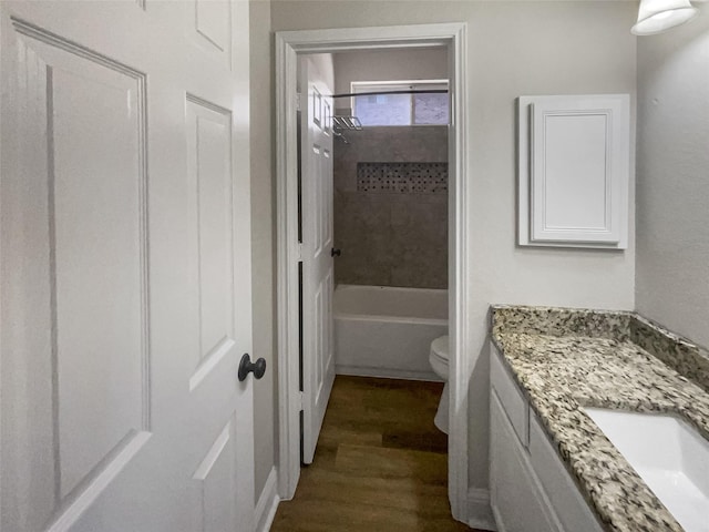 full bathroom featuring vanity, hardwood / wood-style flooring, toilet, and tiled shower / bath