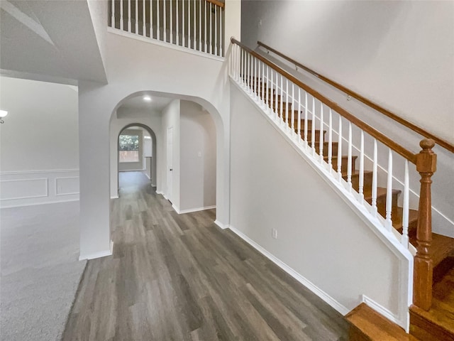 interior space with hardwood / wood-style floors and a towering ceiling