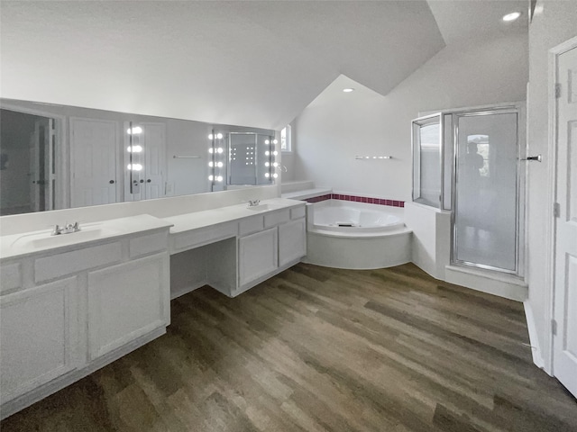 bathroom with vanity, hardwood / wood-style flooring, independent shower and bath, and lofted ceiling