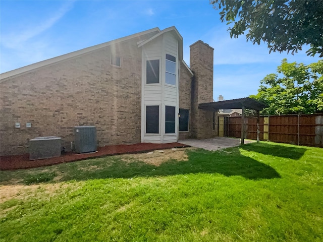 back of property with a patio area, a yard, and central air condition unit