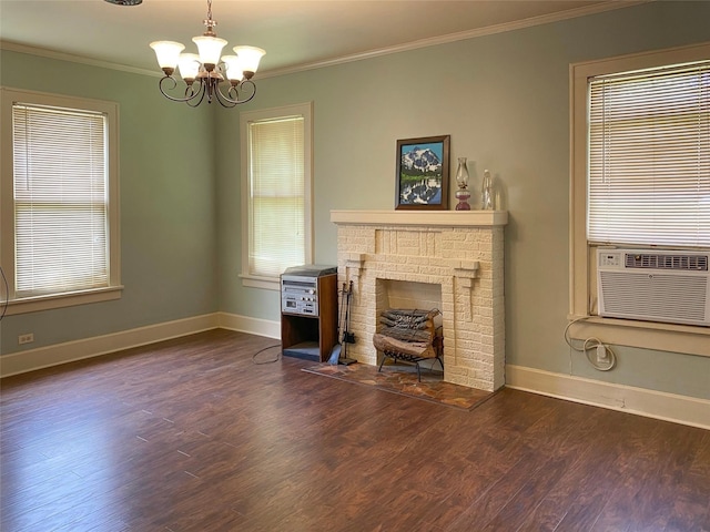 unfurnished living room featuring an inviting chandelier, crown molding, dark hardwood / wood-style flooring, and a brick fireplace