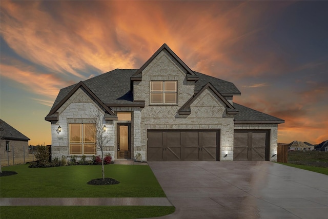 french country home featuring a lawn and a garage