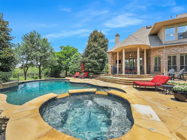 view of pool with an in ground hot tub and a patio