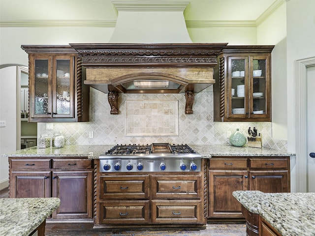 kitchen featuring light stone countertops, stainless steel gas cooktop, and backsplash