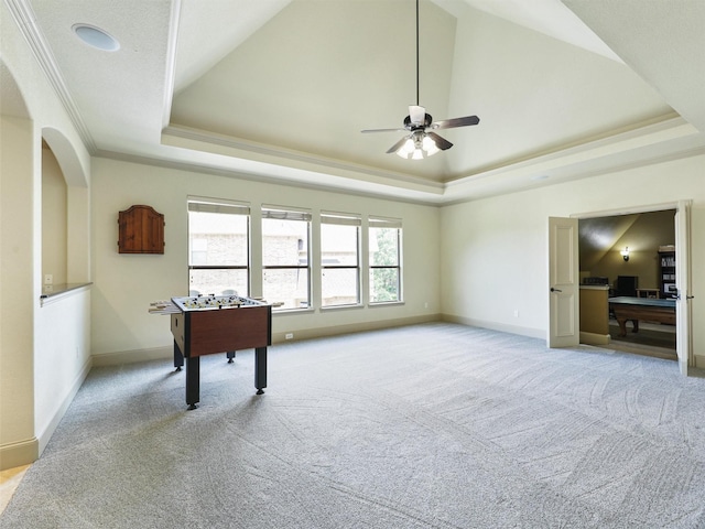 playroom with a tray ceiling, ornamental molding, light colored carpet, and ceiling fan