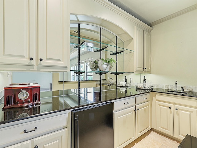 kitchen featuring sink, light tile patterned floors, dark stone countertops, white cabinetry, and ornamental molding