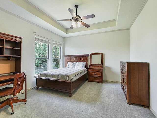 carpeted bedroom with crown molding, a tray ceiling, and ceiling fan