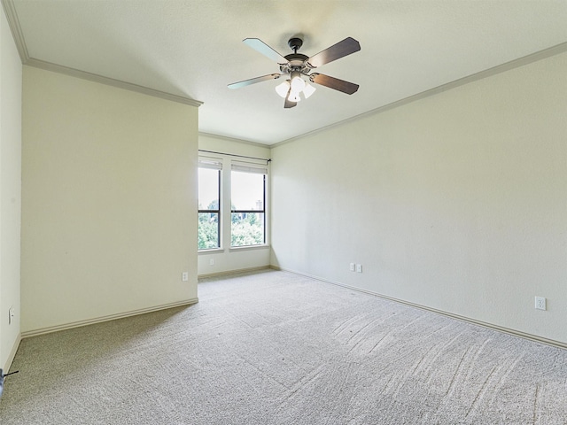 carpeted spare room featuring crown molding and ceiling fan