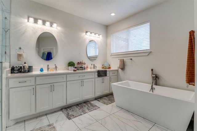 bathroom with marble finish floor, double vanity, and a soaking tub