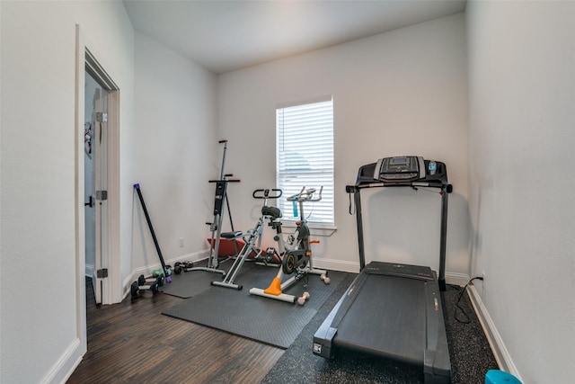 workout room with baseboards and wood finished floors