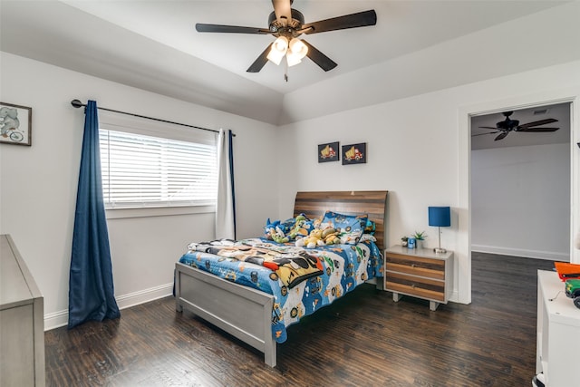 bedroom with lofted ceiling, wood finished floors, a ceiling fan, and baseboards