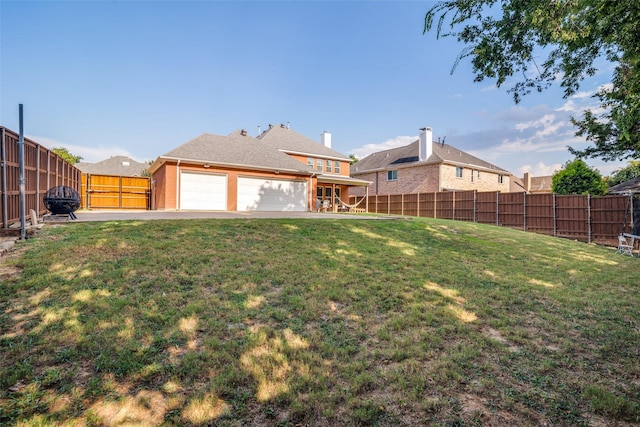 view of yard with a garage and a fenced backyard