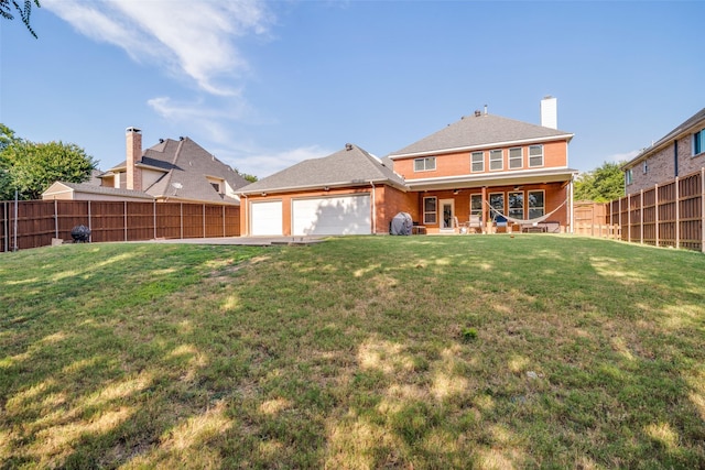 back of house featuring an attached garage, brick siding, a fenced backyard, and a yard