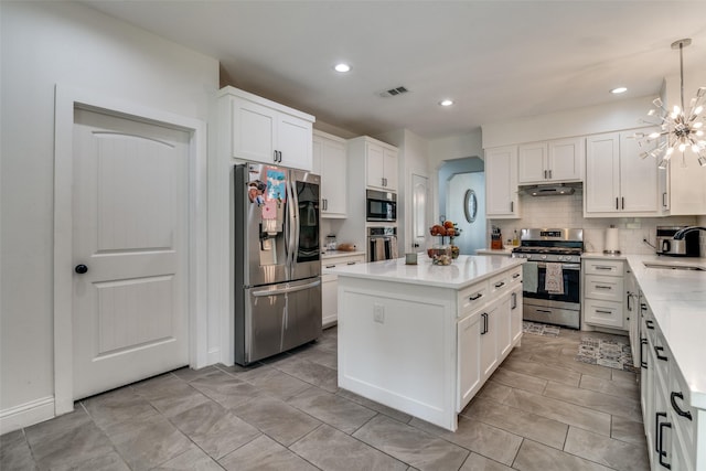 kitchen with stainless steel appliances, tasteful backsplash, light countertops, visible vents, and under cabinet range hood