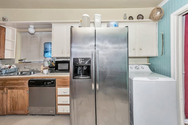 kitchen featuring washer / dryer, sink, white cabinets, light tile patterned floors, and stainless steel appliances