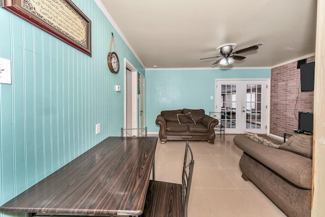 tiled living room with ornamental molding, french doors, ceiling fan, and brick wall