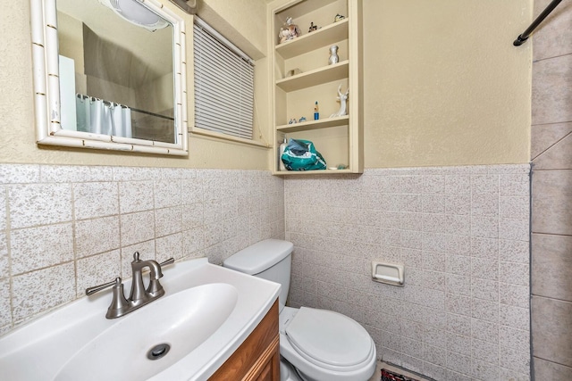 bathroom with vanity, tile walls, toilet, and a shower with shower curtain