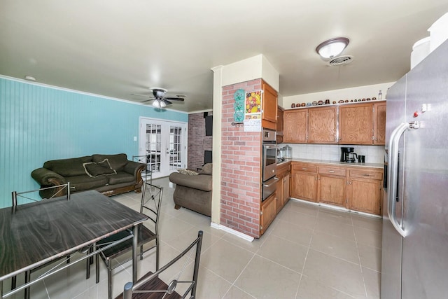 kitchen featuring backsplash, ornamental molding, light tile patterned floors, stainless steel appliances, and french doors