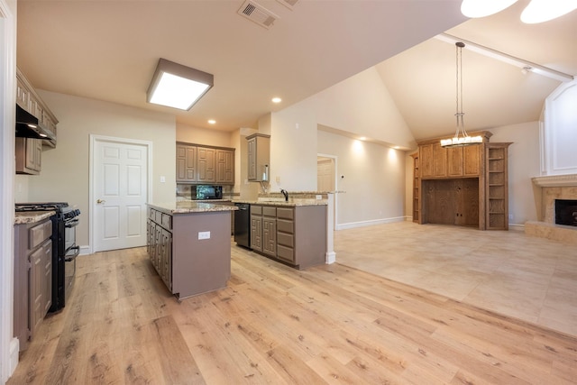 kitchen featuring a tile fireplace, light wood-type flooring, black appliances, and sink