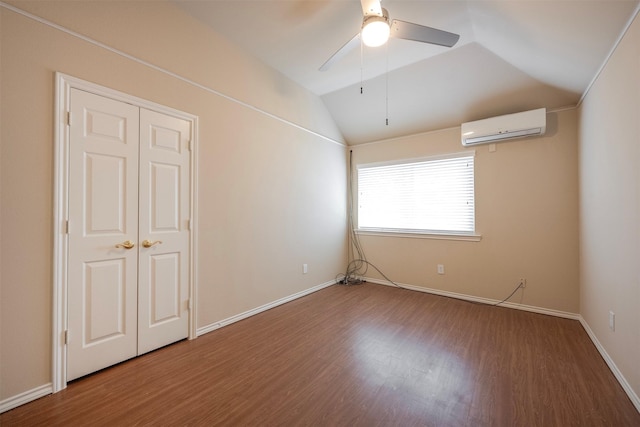 unfurnished room featuring ceiling fan, lofted ceiling, a wall unit AC, and wood-type flooring