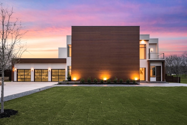 contemporary home with a balcony and a yard