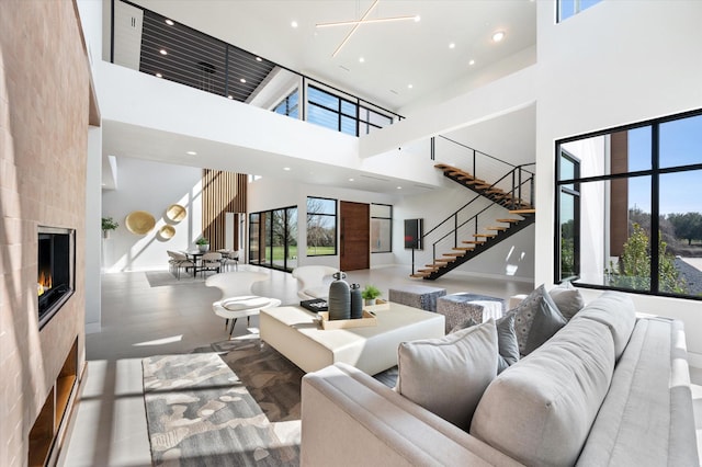 living room with a tiled fireplace and a high ceiling