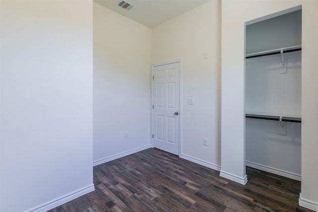 unfurnished bedroom featuring a closet and dark hardwood / wood-style flooring