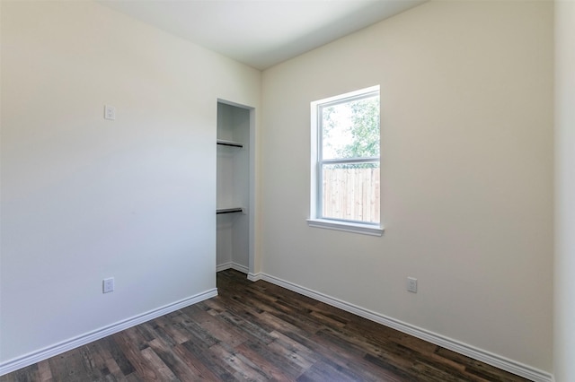 unfurnished bedroom with multiple windows and dark hardwood / wood-style flooring