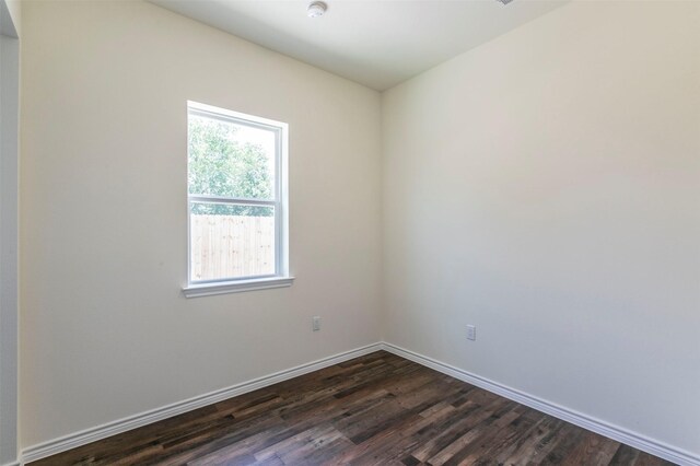 empty room with dark hardwood / wood-style flooring