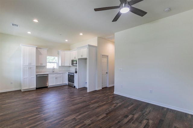 kitchen with appliances with stainless steel finishes, dark hardwood / wood-style flooring, white cabinetry, and sink