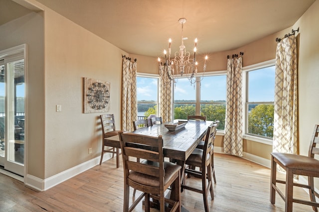 dining room featuring plenty of natural light, an inviting chandelier, and light hardwood / wood-style floors